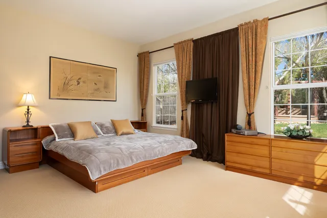 a bedroom with a bed dresser and a window