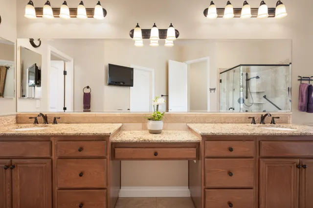 a bathroom with a granite countertop sink and a mirror
