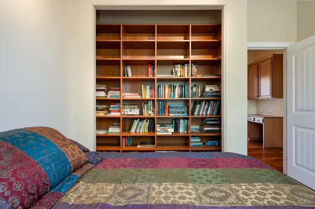 a bedroom with furniture and a book shelf