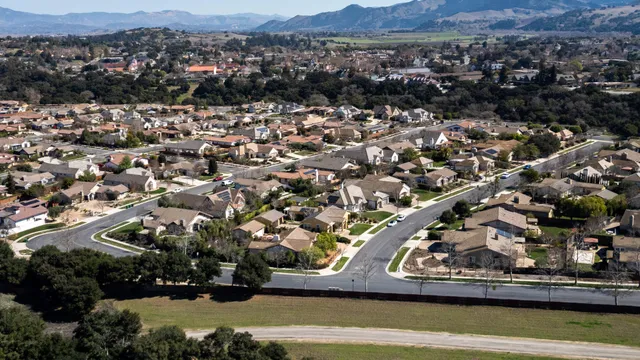 an aerial view of residential houses with outdoor space and trees