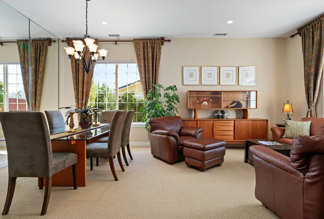 a outdoor living room with furniture a fireplace and a chandelier