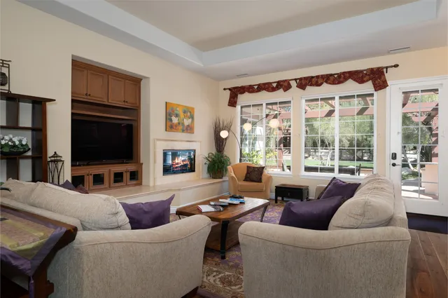 a living room with furniture a flat screen tv and a large window