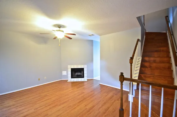 a view of a livingroom with wooden floor and a ceiling fan