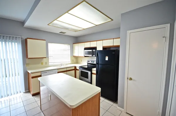 a kitchen with stainless steel appliances granite countertop a refrigerator and a stove top oven
