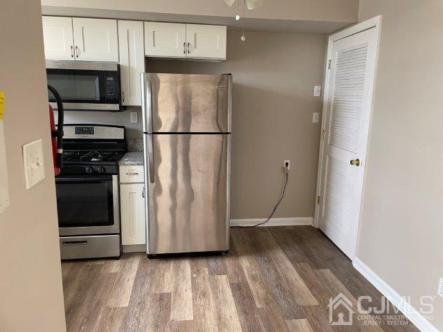 11 Florida Grove Road, Unit 5 Keasbey, NJ 08832 - Photo 8 of 12 a kitchen with wooden cabinets and stainless steel appliances