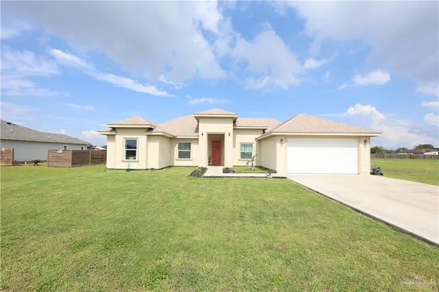 a view of a yard in front of a house with a large tree