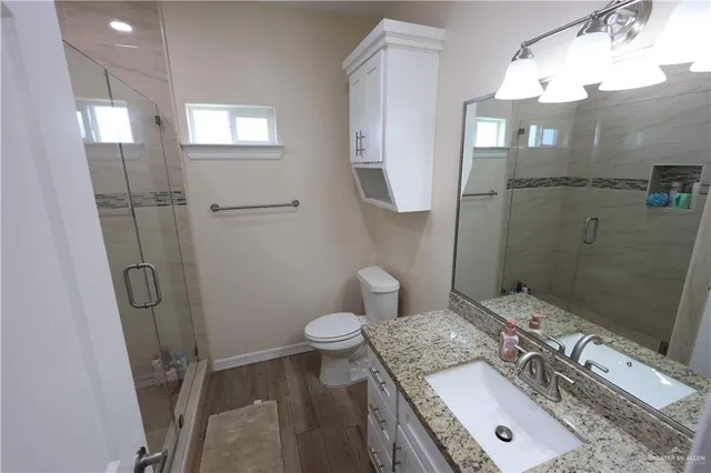a bathroom with a granite countertop sink toilet and shower