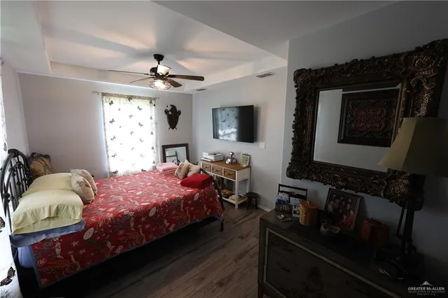 a bedroom with a bed wooden floor and window