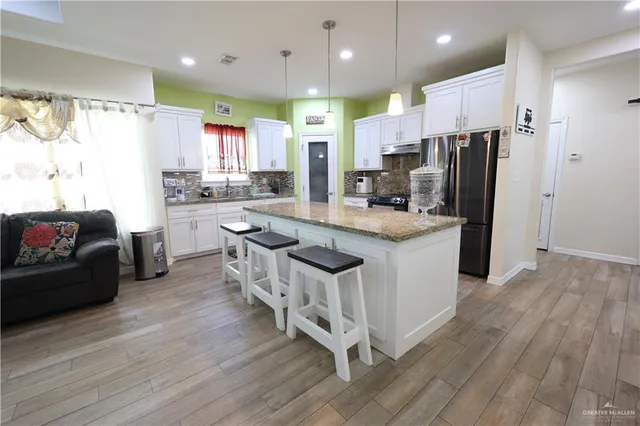 a kitchen with stainless steel appliances a stove a sink a refrigerator and cabinets