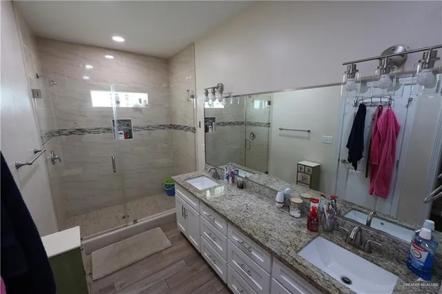a bathroom with a granite countertop sink a toilet and shower