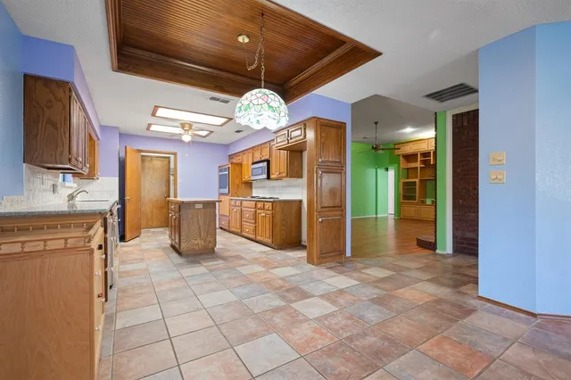 a kitchen with a stove top oven cabinets a sink and a refrigerator