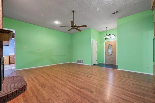 an empty room with a fan and a fireplace