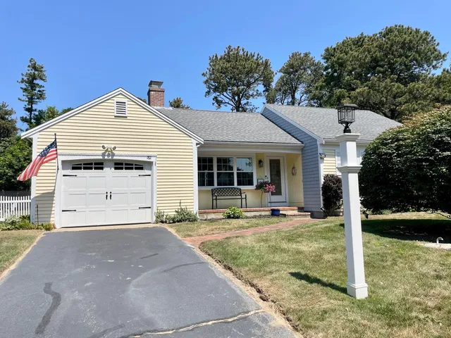 a front view of a house with garden and yard