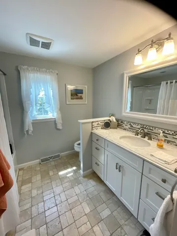 a spacious bathroom with a granite countertop sink a mirror and a