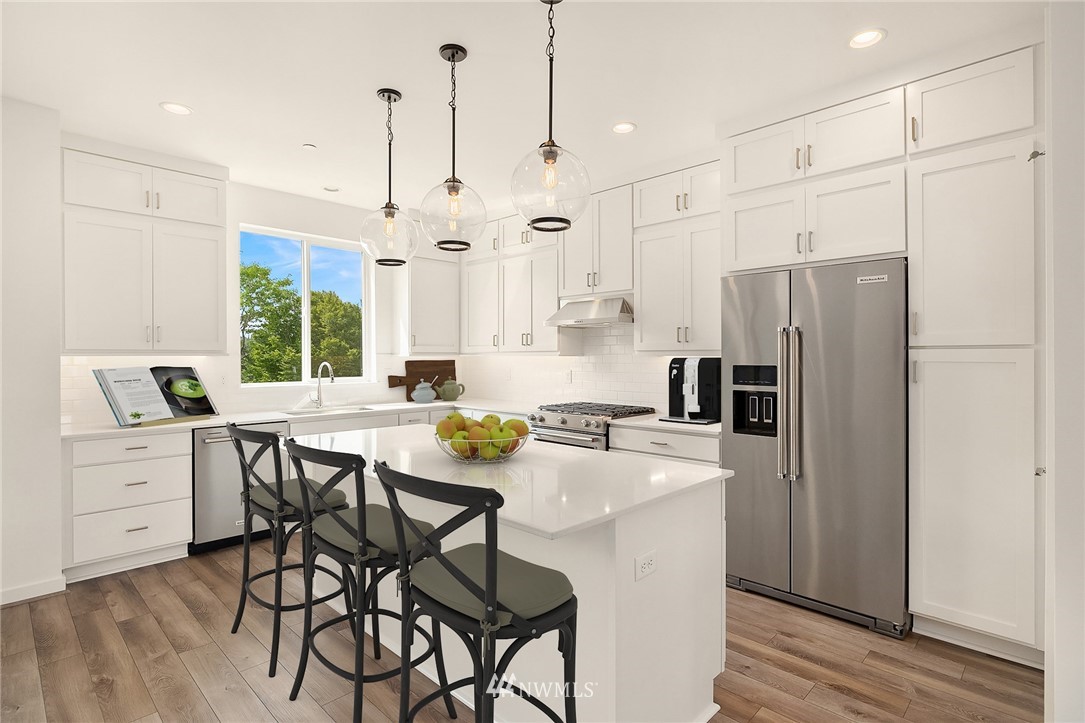 21711 25th (site 17) Street Southeast, Unit C Bothell, WA 98021 - Photo 3 of 10 a kitchen with stainless steel appliances a refrigerator a stove a sink and a refrigerator with wooden floor