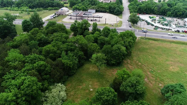 an aerial view of residential house with outdoor space and trees all around