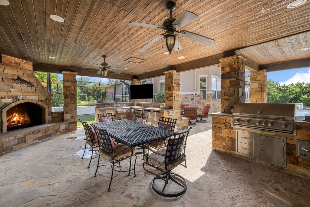 109 Largo Cove Austin, TX 78734 - Photo 37 of 40 An inviting covered patio featuring a robust outdoor fireplace and a fully equipped built-in barbecue area.