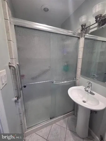 a bathroom with a sink shower and a mirror