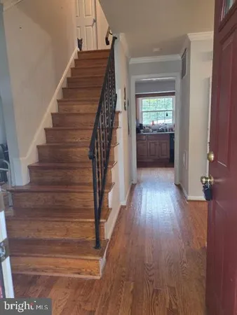 a view of entryway and hall with wooden floor