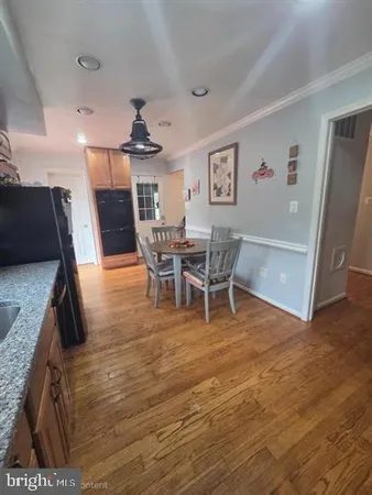 a living room with stainless steel appliances furniture and a kitchen view