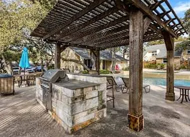 a view of a patio with table and chairs a barbeque with wooden fence and floor