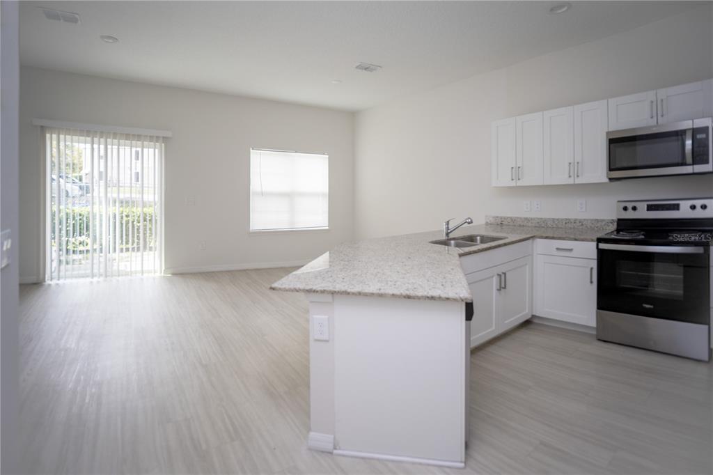 2148 Penny Lane Kissimmee, FL 34741 - Photo 4 of 15 a kitchen with stainless steel appliances a stove top oven and cabinets