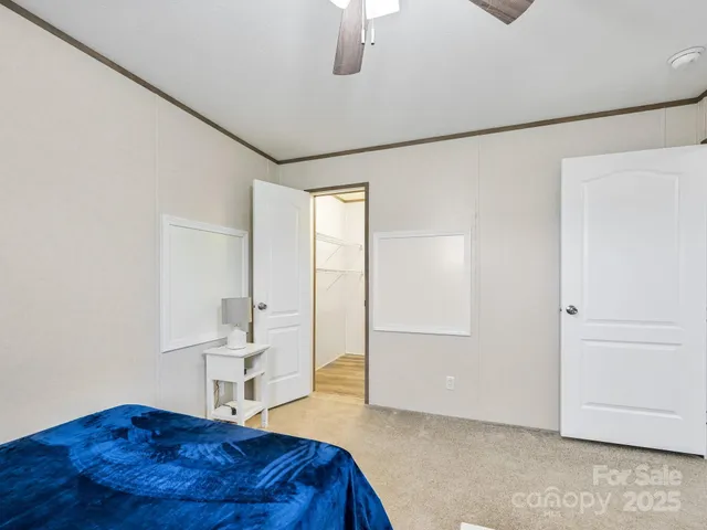 a bedroom with a bed and a lamp on the dresser