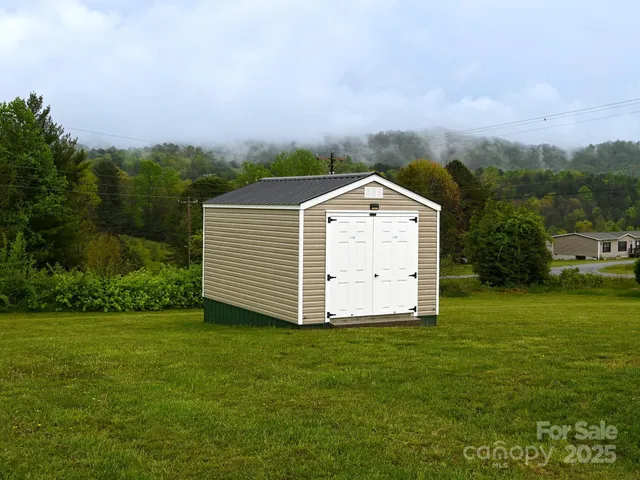 a front view of a house with a yard and trees