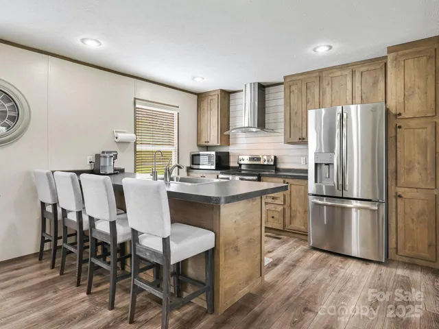 a kitchen with a refrigerator a stove a dining table and chairs