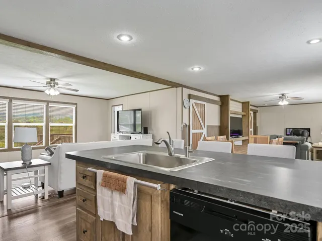 a kitchen with stainless steel appliances granite countertop a sink a stove and a refrigerator