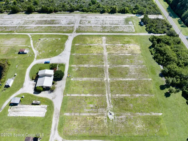 an aerial view of a residential houses with yard