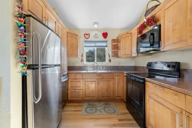 a kitchen with stainless steel appliances granite countertop a refrigerator and a sink