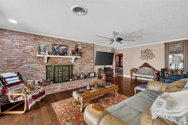 a kitchen with stainless steel appliances granite countertop a refrigerator a stove a sink a dining table and chairs with wooden floor