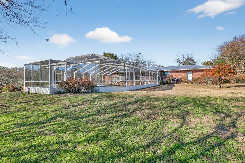 2230 Southwest 87th Place Ocala, FL 34476 - Photo 38 of 42 a view of a house with a yard and a table under an umbrella