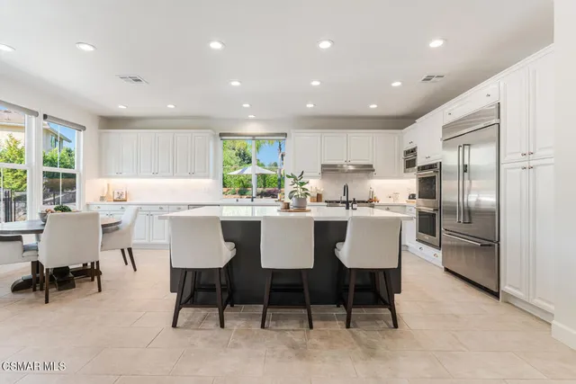 a kitchen with white cabinets and appliances