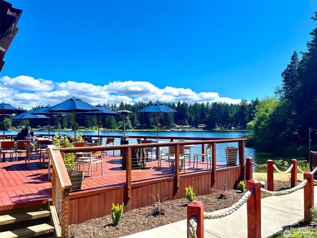 a view of a swimming pool with lawn chairs and a big yard