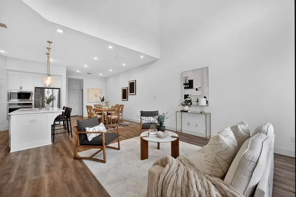 a living room with furniture and kitchen view