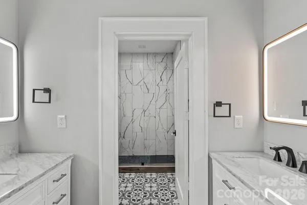 a bathroom with a granite countertop sink a mirror and shower