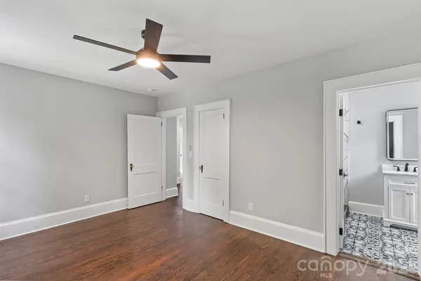 an empty room with wooden floor and ceiling fan