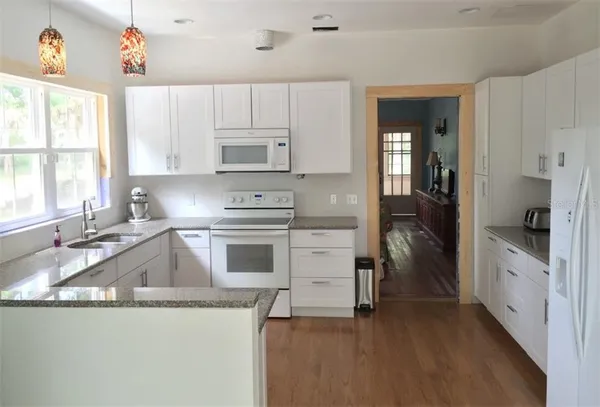 a kitchen with granite countertop a sink and cabinets
