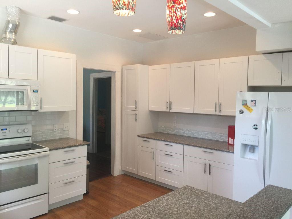 Undisclosed Address Bradenton, FL 34208 - Photo 6 of 13 a kitchen with white cabinets and white appliances