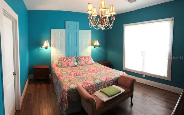 a bedroom with a bed and a chandelier