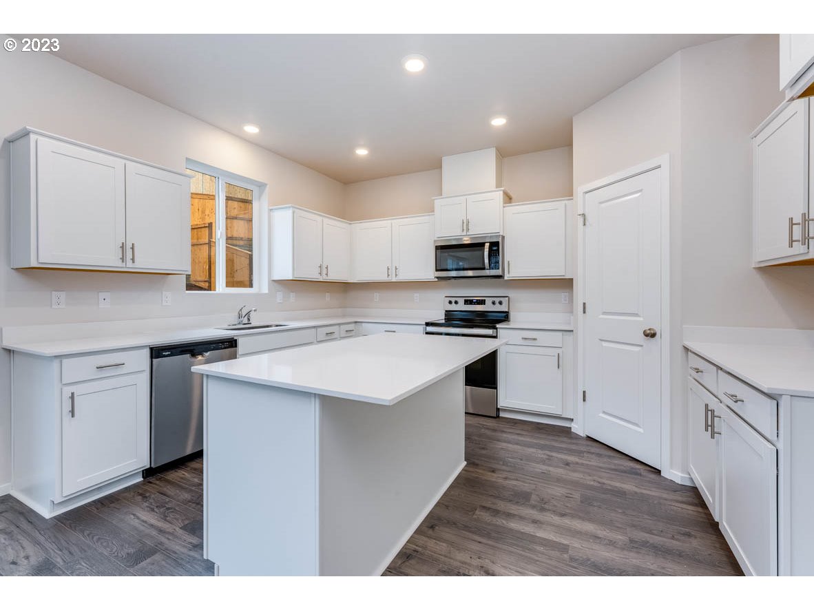 3217 Southeast 35th Street Gresham, OR 97080 - Photo 12 of 30 a kitchen with kitchen island white cabinets appliances and a sink