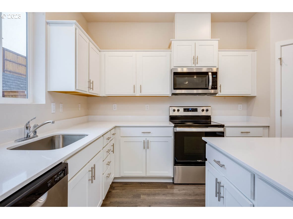 3217 Southeast 35th Street Gresham, OR 97080 - Photo 14 of 30 a kitchen with stainless steel appliances granite countertop a sink a stove a microwave and cabinets