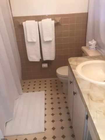 a bathroom with a granite countertop sink a toilet and a mirror