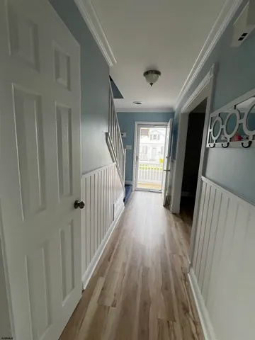 a view of a hallway with wooden floor and staircase