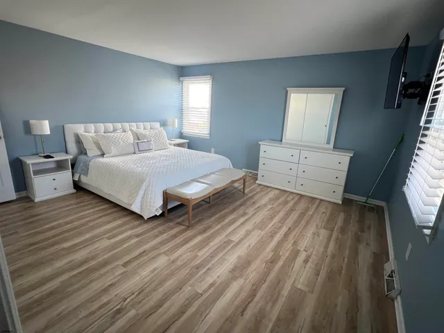 a spacious bedroom with a bed and a dresser