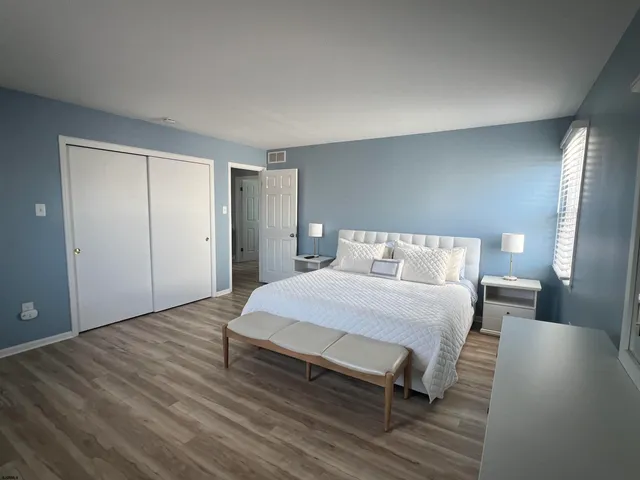 a spacious bedroom with a bed and wooden floor