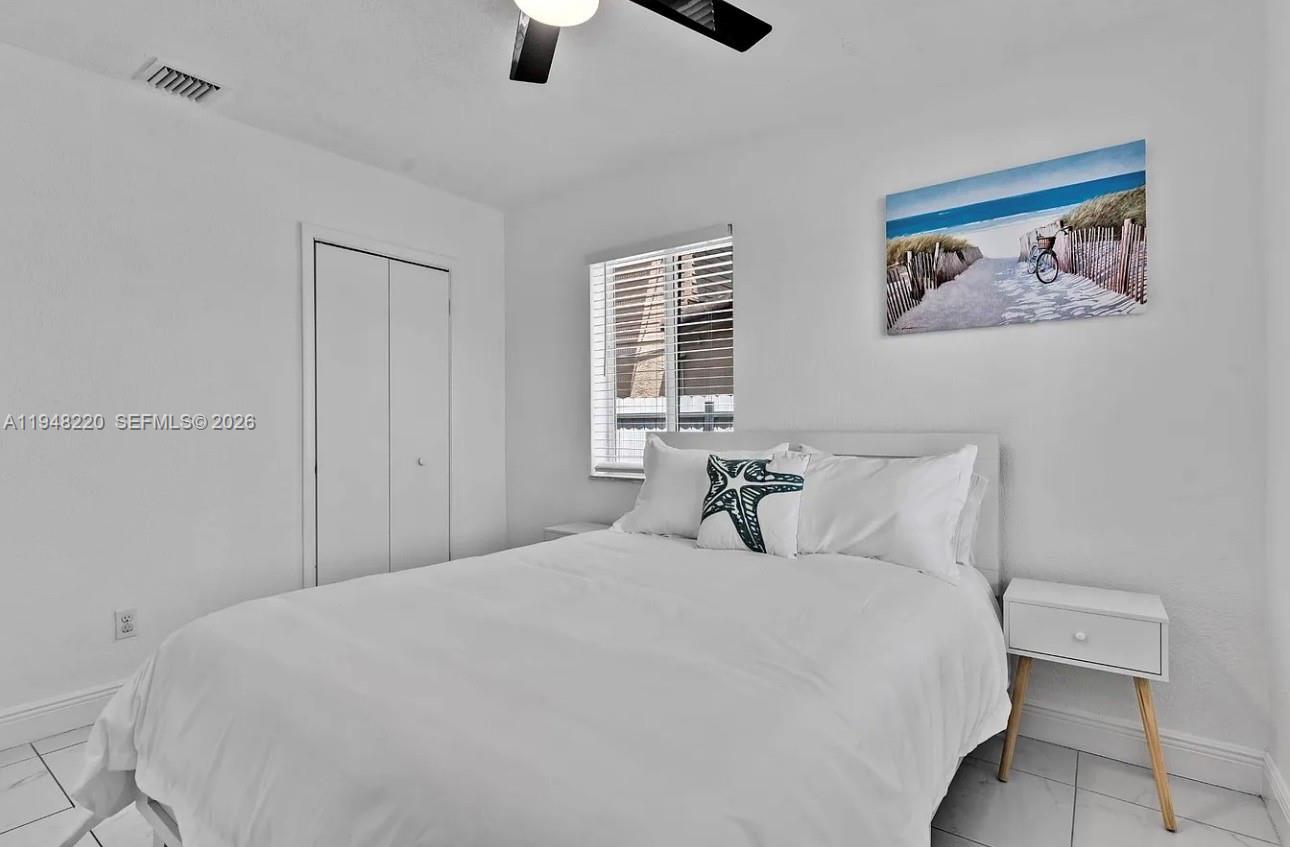 211 Southeast 3rd Street Dania Beach, FL 33004 - Photo 13 of 20 a bedroom with a large bed and a chandelier