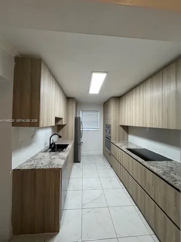 a kitchen with stainless steel appliances granite countertop a sink stove and cabinets